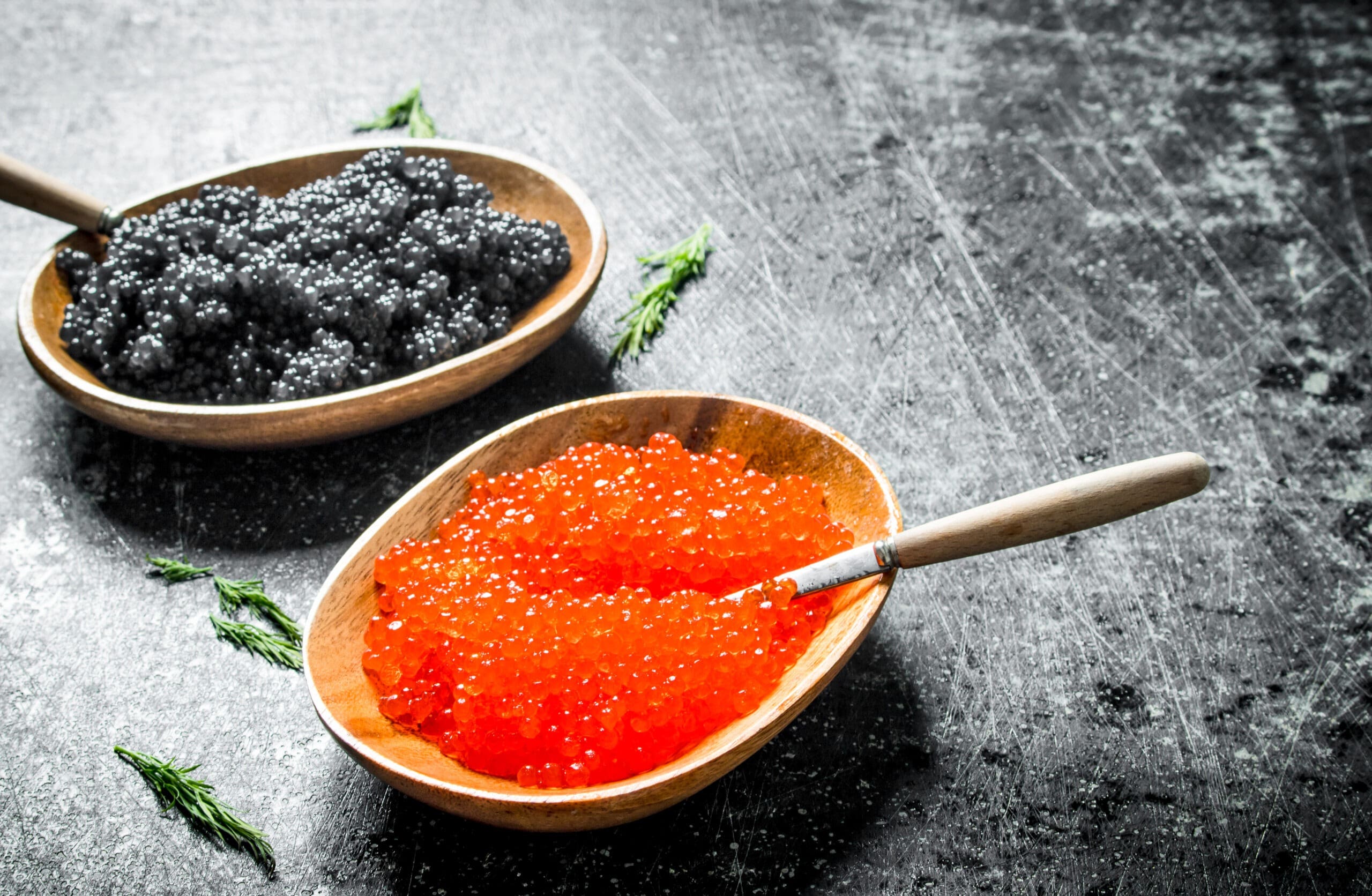 black caviar and Trout roe in bowls with spoons