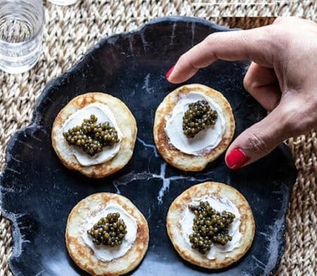 caviar blinis on gray tray