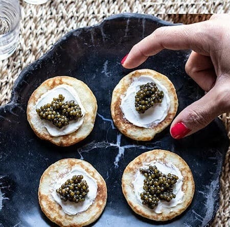 caviar blinis on gray tray