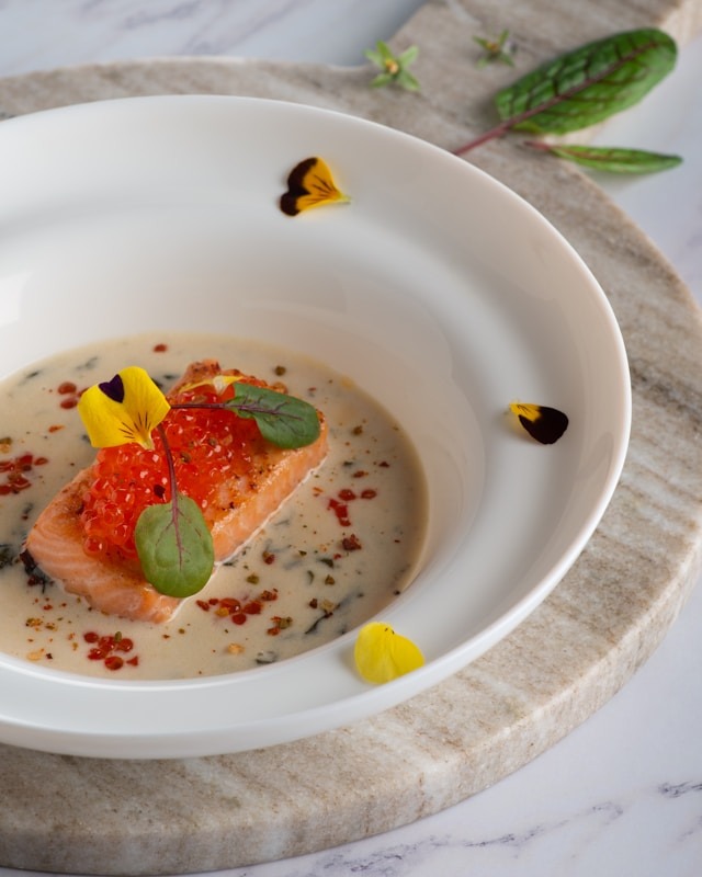 plate of salmon with red caviar and flower garnish