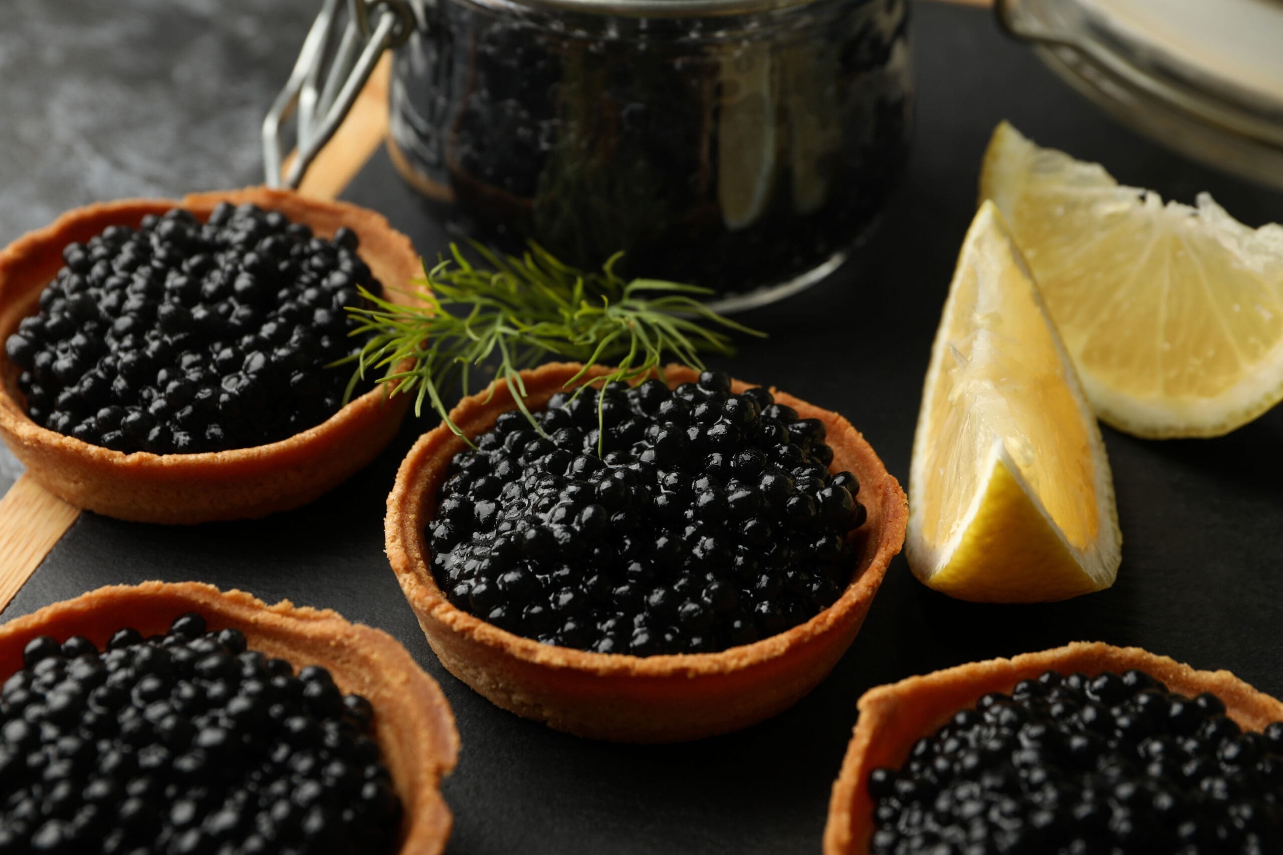 tartlets with caviar and lemon on serving tray