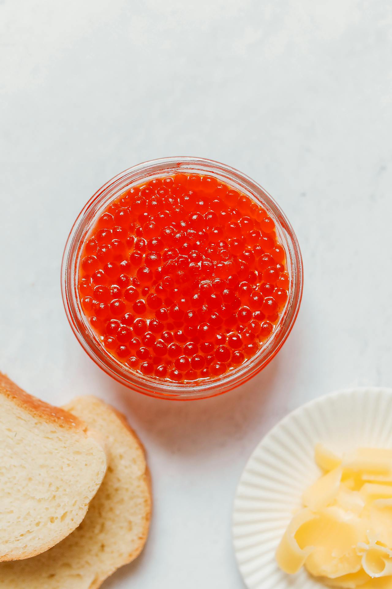 bowl of red caviar next to bread and butter