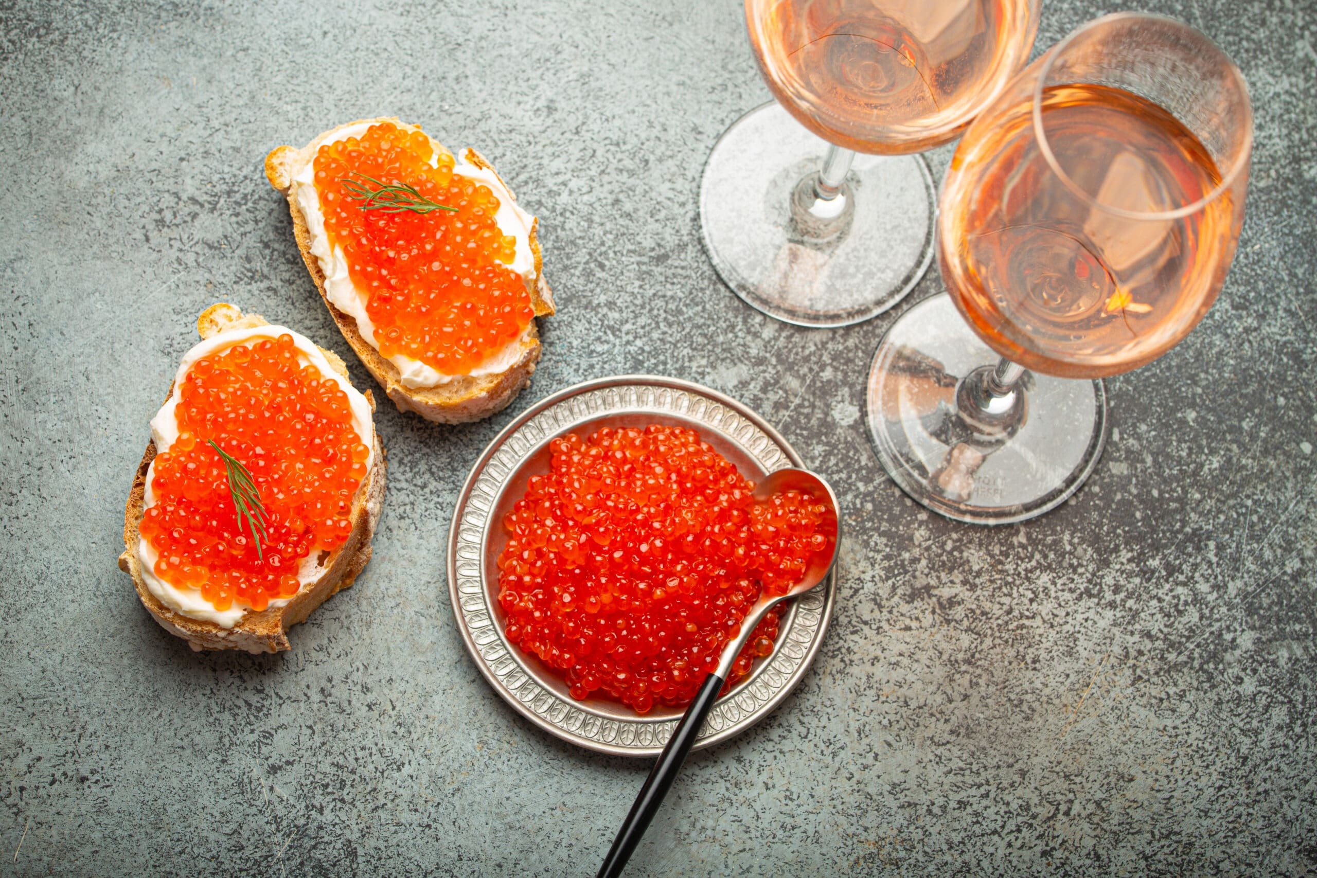 plate of Chum caviar, two roe appetizers, and two glasses of wine