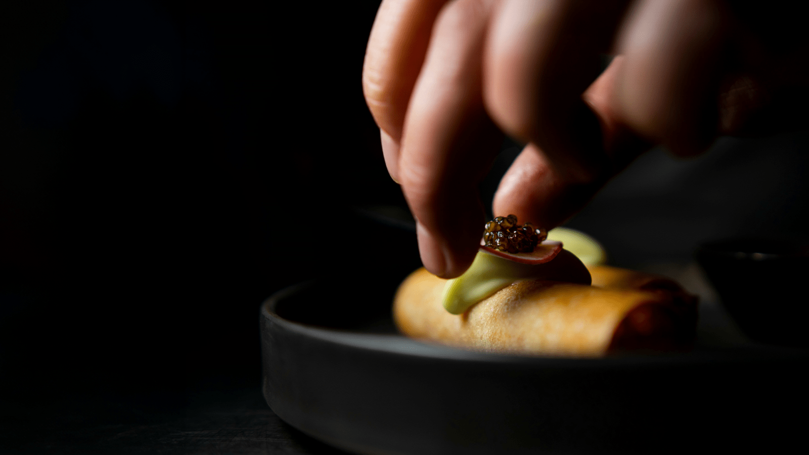 person making gourmet food with caviar