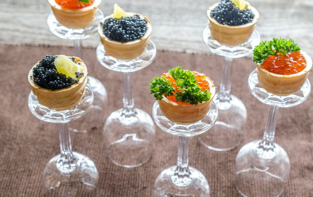 Caviar and roe sandwiches served on the base of wine glasses