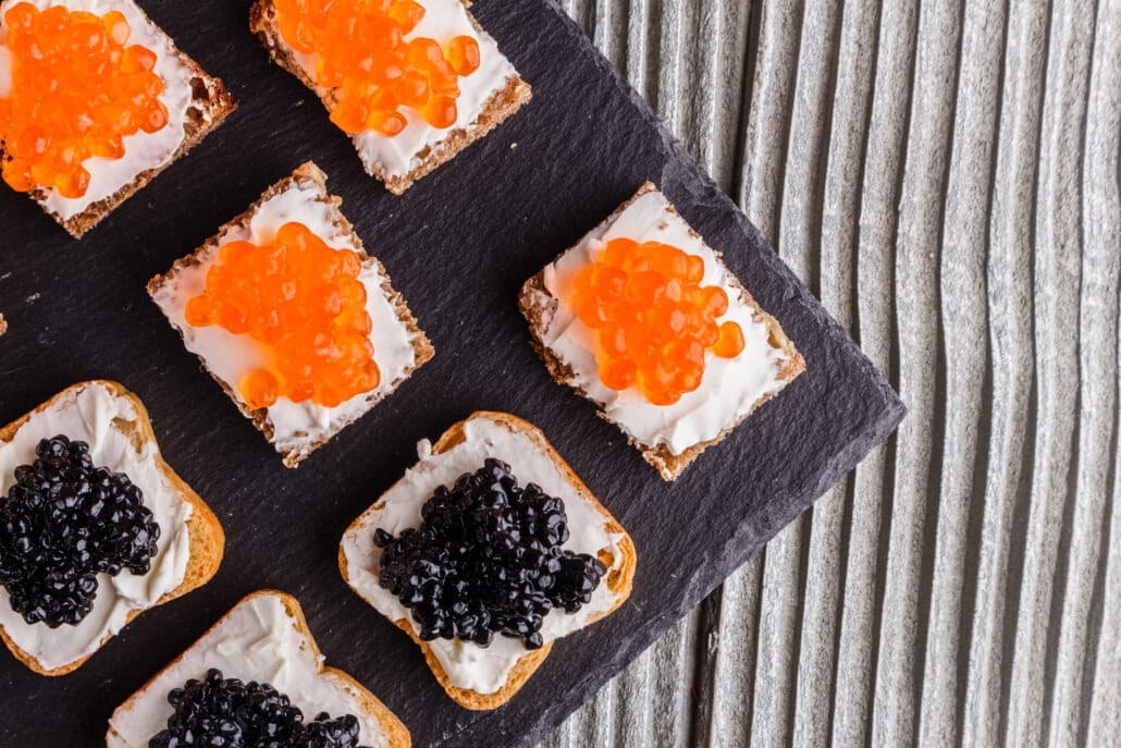 A plate of caviar and roe on crackers