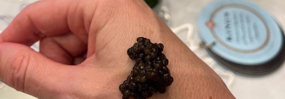 A dollop of caviar on the back of a person’s hand